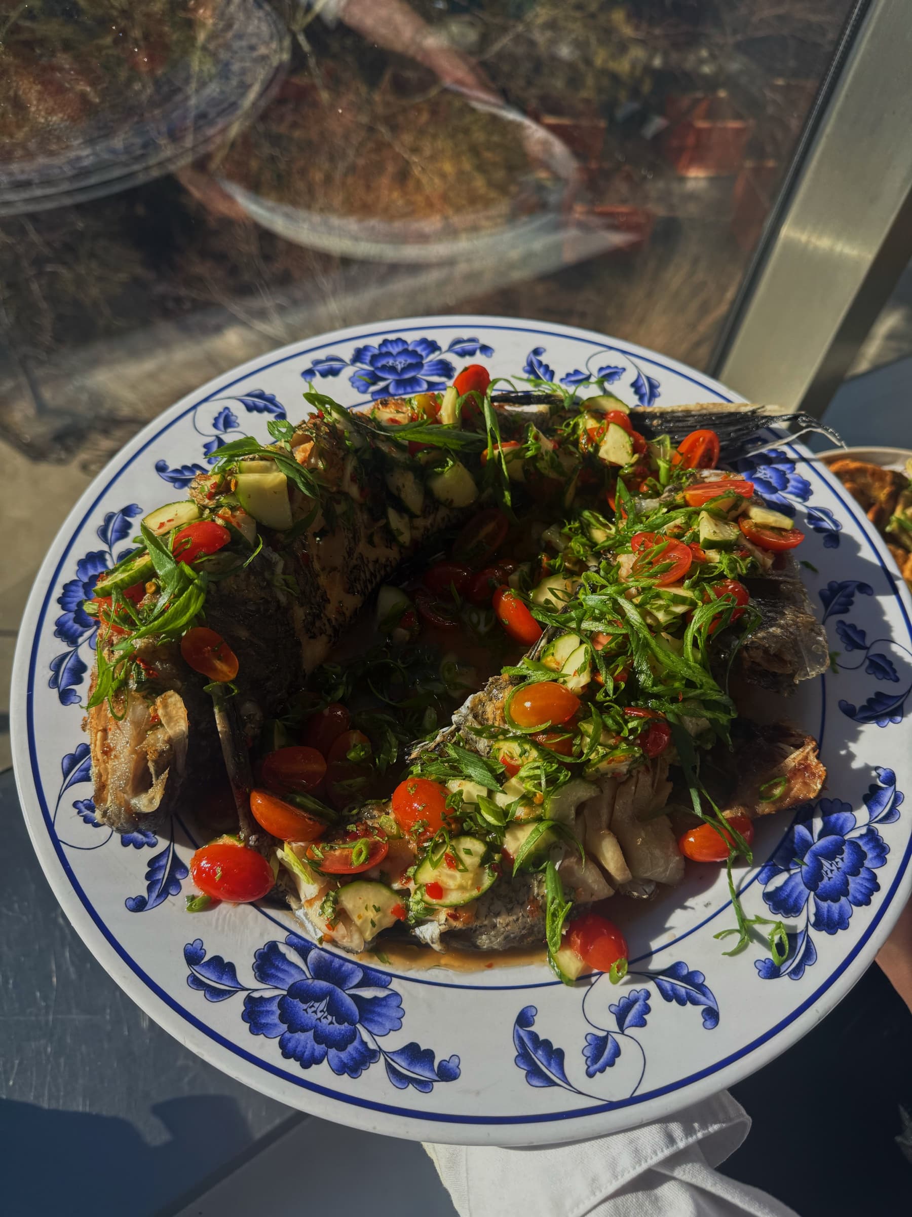 A whole fish served on a blue and white plate