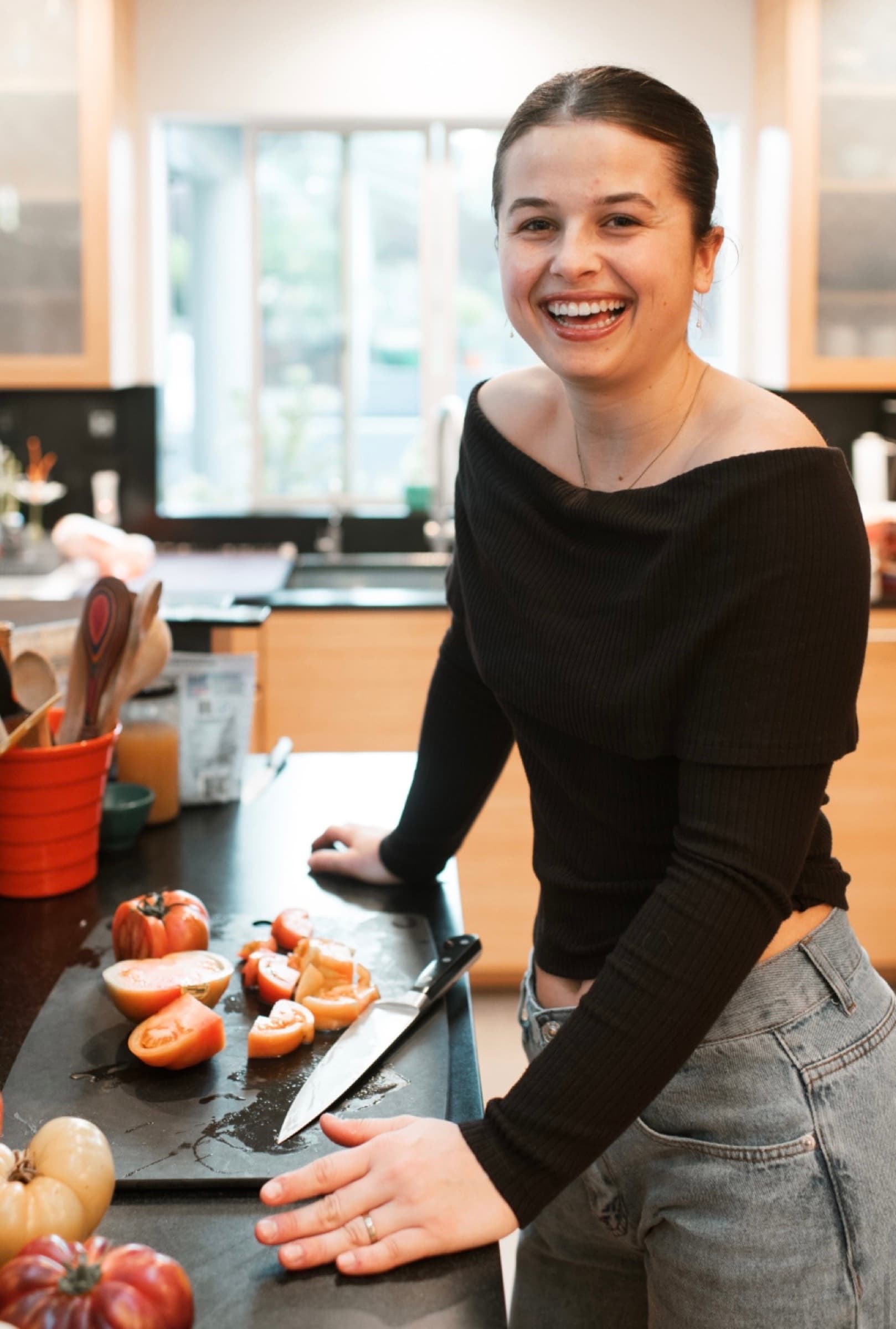 A smiling cook standing at a kitchen counter